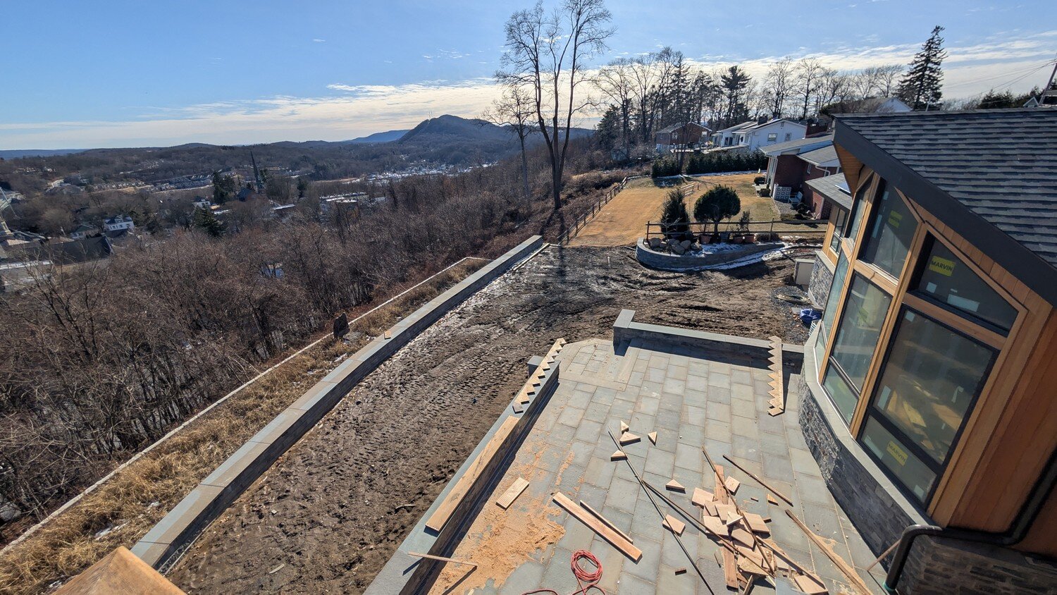 View of a Hudson Valley hillside and stone terrace during home construction