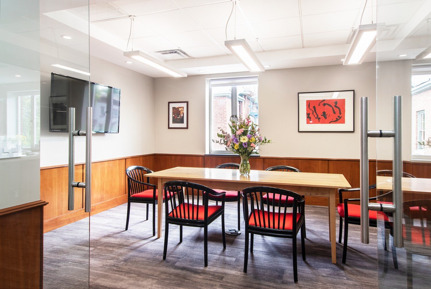 Meeting space with glass walls, wood finishes and natural light